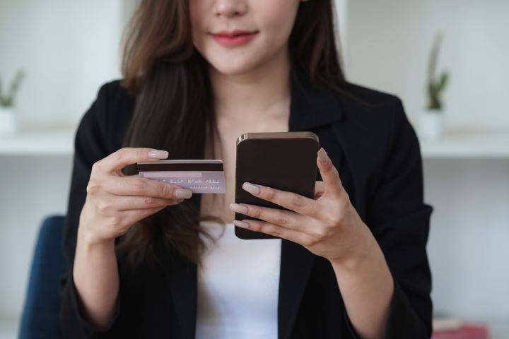 Ung kvinde der bruger et kreditkort til at købe - Eksempel på når e-commerce strategi lykkedes