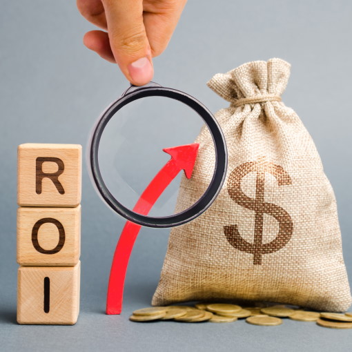 ordet ROI stavet med træklodser ved siden af en pose penge